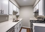 Thumbnail 4 of 7 - an empty kitchen with white cabinets and appliances and a sink