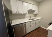 Thumbnail 6 of 7 - a kitchen with white cabinets and a stainless steel dishwasher