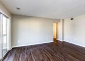 Thumbnail 1 of 7 - an empty living room with wood floors and white walls
