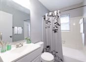 Thumbnail 15 of 15 - a white bathroom with a shower curtain and a sink
