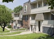 Thumbnail 13 of 15 - A row of townhouses with a tree in the front yard.