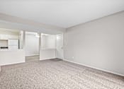 Thumbnail 5 of 15 - A spacious room with a carpeted floor and a door leading to another room.