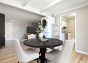 Thumbnail 15 of 25 - A modern dining room with a round table and white chairs.