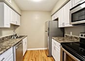 Thumbnail 20 of 25 - A kitchen with a granite counter top and stainless steel appliances.