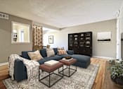 Thumbnail 3 of 25 - A living room with a dark blue couch and a coffee table.