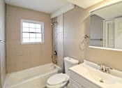 Thumbnail 25 of 25 - A bathroom with a toilet, sink, and bathtub.
