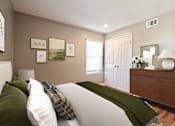 Thumbnail 13 of 25 - A bedroom with a bed, dresser, and pictures on the wall.