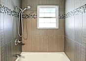 Thumbnail 22 of 25 - A bathroom with a white tub and a window.
