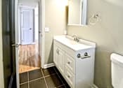 Thumbnail 23 of 25 - A white sink with a mirror above it and a white towel hanging on the wall.