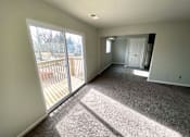 Thumbnail 2 of 28 - A sunny day with a carpeted room and sliding glass doors.