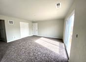 Thumbnail 4 of 28 - A large empty room with carpeted floor and white walls.