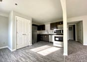 Thumbnail 9 of 28 - A kitchen with a white door and a microwave above the stove.