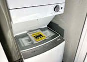 Thumbnail 7 of 28 - A white washing machine with a sticker on the door.