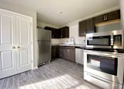 Thumbnail 8 of 28 - A kitchen with a stainless steel refrigerator, microwave, and oven.