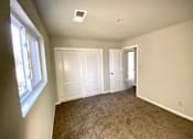 Thumbnail 24 of 28 - A room with carpeted floor and two doors.