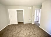 Thumbnail 17 of 28 - A room with a carpeted floor and a closet with a door open.