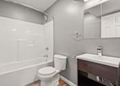 Thumbnail 8 of 10 - A white toilet sits next to a sink in a bathroom.