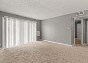 Thumbnail 3 of 10 - A room with a carpeted floor and a window with blinds.