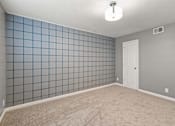 Thumbnail 4 of 10 - A room with a white door and a blue tile wall.