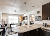 Thumbnail 10 of 25 - A modern kitchen and living room with a large island in the center.