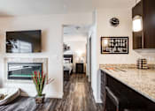 Thumbnail 15 of 25 - A modern kitchen with a fireplace and a clock on the wall.