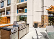 Thumbnail 11 of 25 - A modern outdoor kitchen with a grill and sink.
