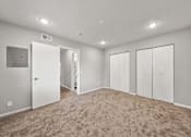 Thumbnail 13 of 20 - A spacious room with carpeted flooring and white walls.