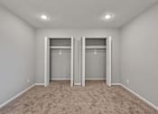Thumbnail 15 of 20 - A room with two closets and carpeted floor.