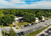 Thumbnail 5 of 20 - A parking lot with cars and a building in the background.