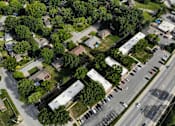 Thumbnail 4 of 20 - A bird's eye view of a residential area with houses, trees, and a parking lot.