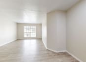 Thumbnail 2 of 14 - an empty living room with white walls and a window