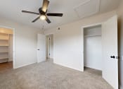 Thumbnail 9 of 14 - an empty bedroom with a ceiling fan and closet