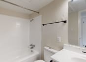 Thumbnail 11 of 14 - a bathroom with a white toilet and a tub and a sink