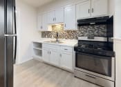 Thumbnail 7 of 14 - a kitchen with stainless steel appliances and white cabinets