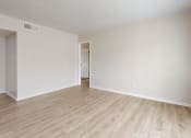 Thumbnail 5 of 14 - an empty living room with wood flooring and white walls