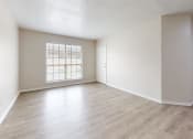 Thumbnail 1 of 14 - an empty living room with hardwood flooring and a window