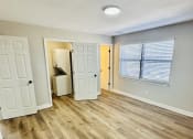 Thumbnail 35 of 39 - an empty living room with wood flooring and a door to a bathroom