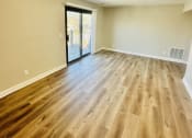 Thumbnail 14 of 39 - an empty living room with wood floors and a sliding glass door