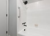 Thumbnail 32 of 39 - a bathroom with white tiles and a white bathtub
