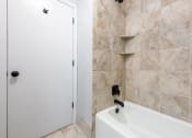 Thumbnail 31 of 39 - a bathroom with a white bathtub and a white door