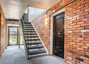 Thumbnail 7 of 39 - the front door of a brick building with a staircase leading up to it