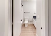 Thumbnail 33 of 39 - a renovated bathroom with white walls and wood floors