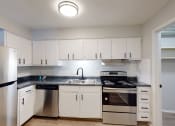 Thumbnail 24 of 39 - a kitchen with white cabinets and stainless steel appliances