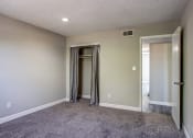 Thumbnail 9 of 16 - a living room with a carpeted floor and a door to a closet
