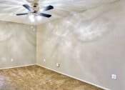 Thumbnail 5 of 28 - an empty room with a ceiling fan and carpet