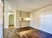 Thumbnail 7 of 28 - an empty living room with wood flooring and a kitchen