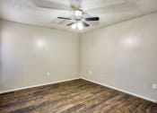 Thumbnail 13 of 28 - an empty living room with a ceiling fan and wood flooring