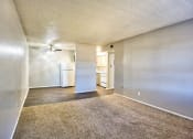Thumbnail 12 of 28 - an empty living room with a ceiling fan and a kitchen