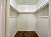 Thumbnail 18 of 28 - a walk in closet with white walls and a wood floor
