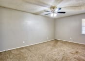 Thumbnail 17 of 28 - an empty living room with a ceiling fan and carpet